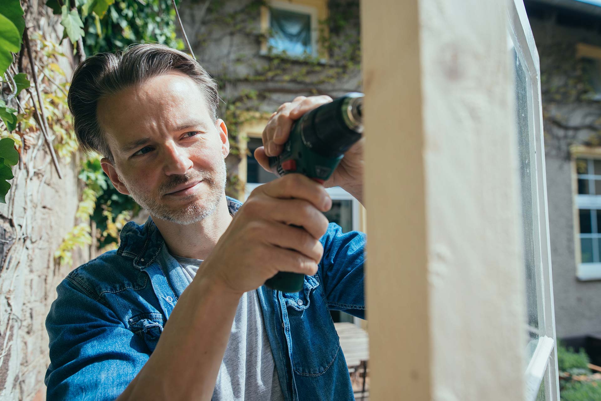 Kaufen Sie das Holz für den Holzbau und Ihr Projekt im Holzhandel Mann baut mit Holz in seinem Garten